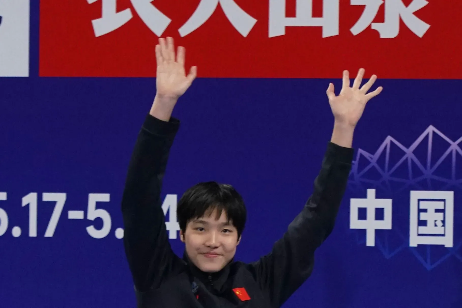 يو زيدي، السباحة الصينية البالغة من العمر 12 عامًا، ترفع يديها احتفالًا بعد تحقيق أوقات مذهلة في السباحة، مرشحة للمنافسة في بطولة العالم.