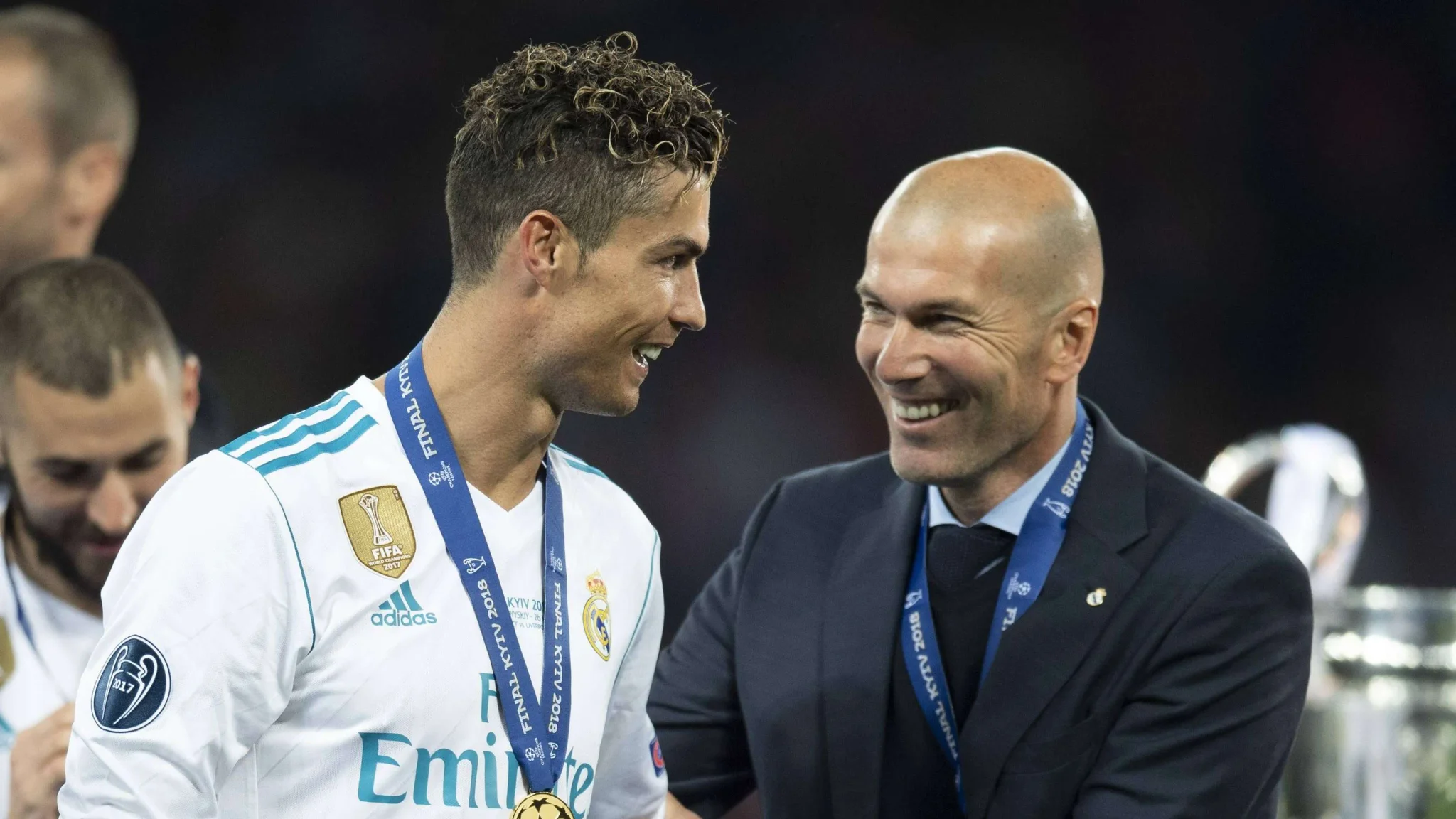 زين الدين زيدان يبتسم ويتحدث مع كريستيانو رونالدو بعد فوز ريال مدريد بدوري أبطال أوروبا، مع تأكيده على مسيرة رونالدو الدولية المميزة.